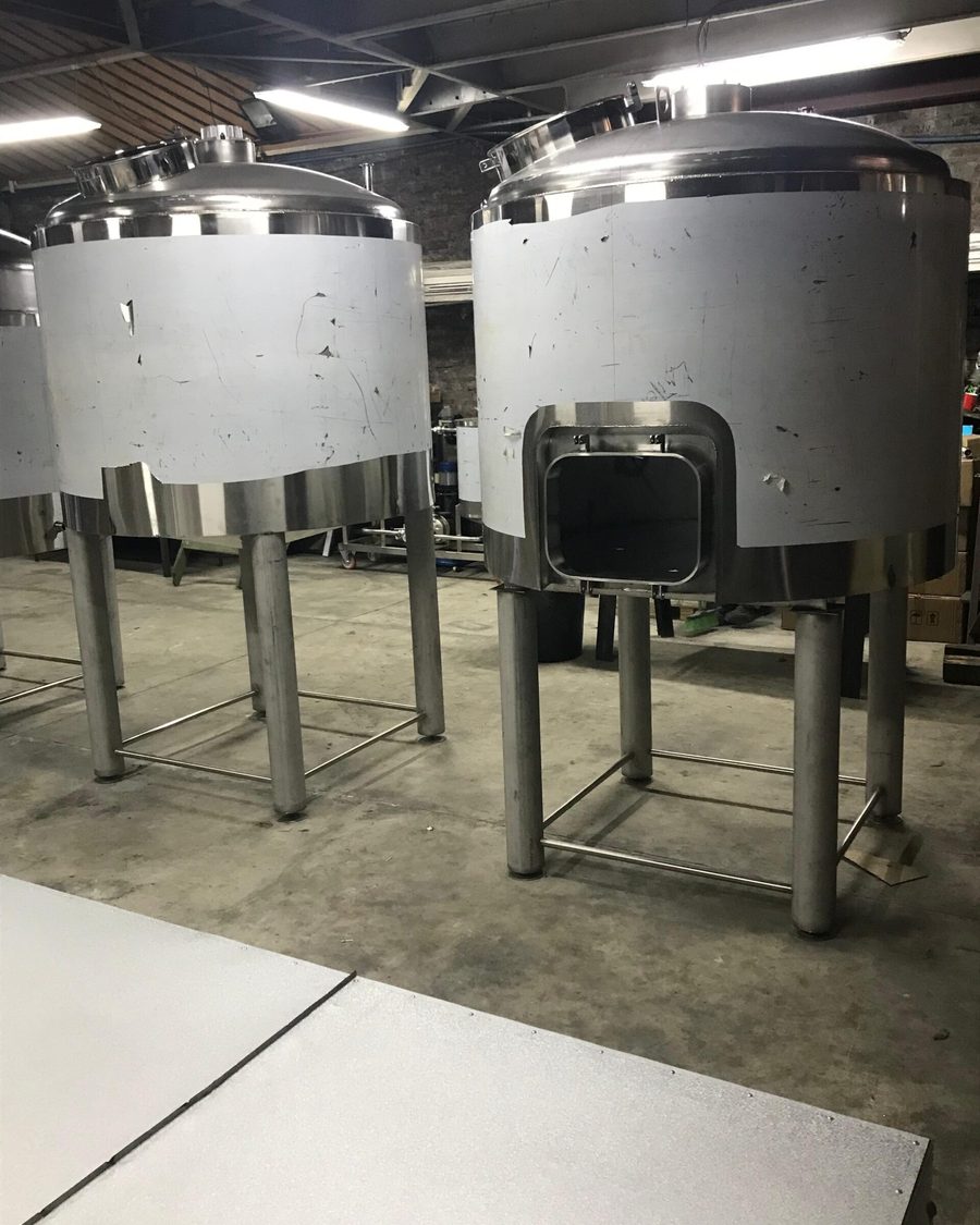 Dos estanques de acero inoxidable con patas en el taller