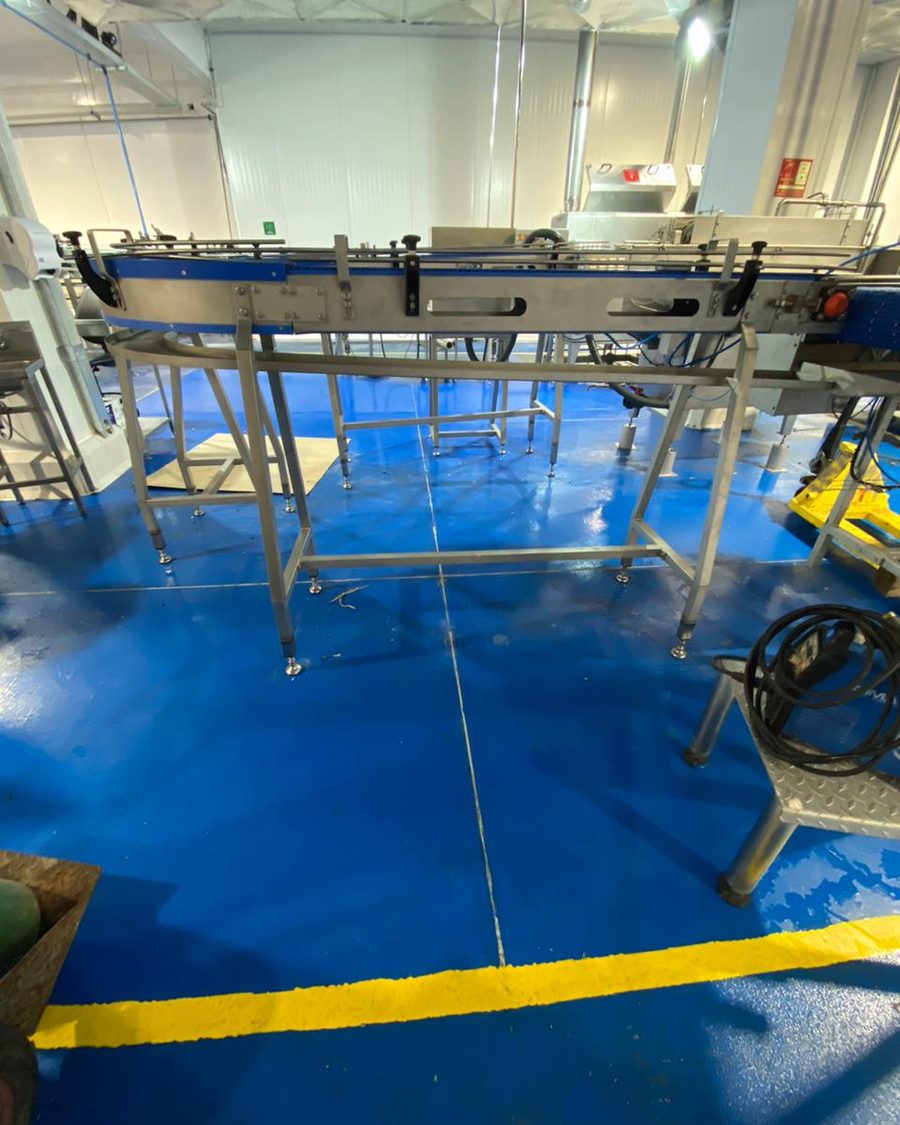 Línea de producción montada en una planta con piso azul