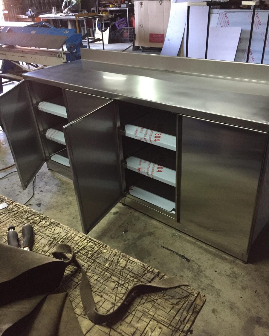 Mueble de acero inoxidable con repisas en el taller