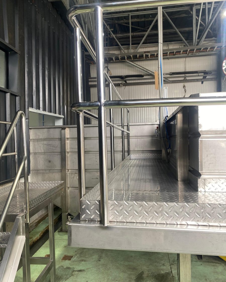 Plataforma de acero inoxidable con pasamanos y piso de plancha diamantada