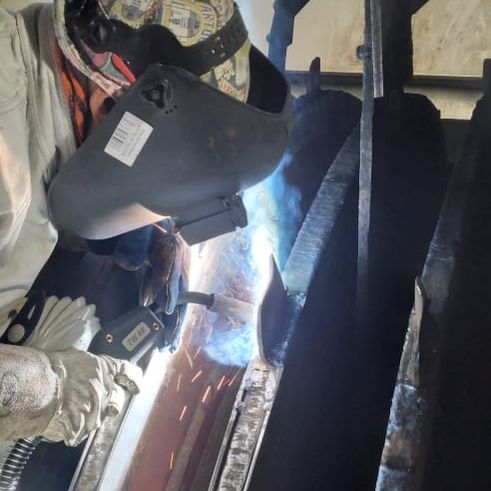 Soldador trabajando en una pieza de acero